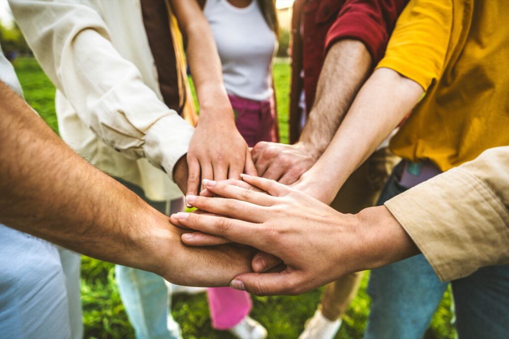 Friends stacking their hands together